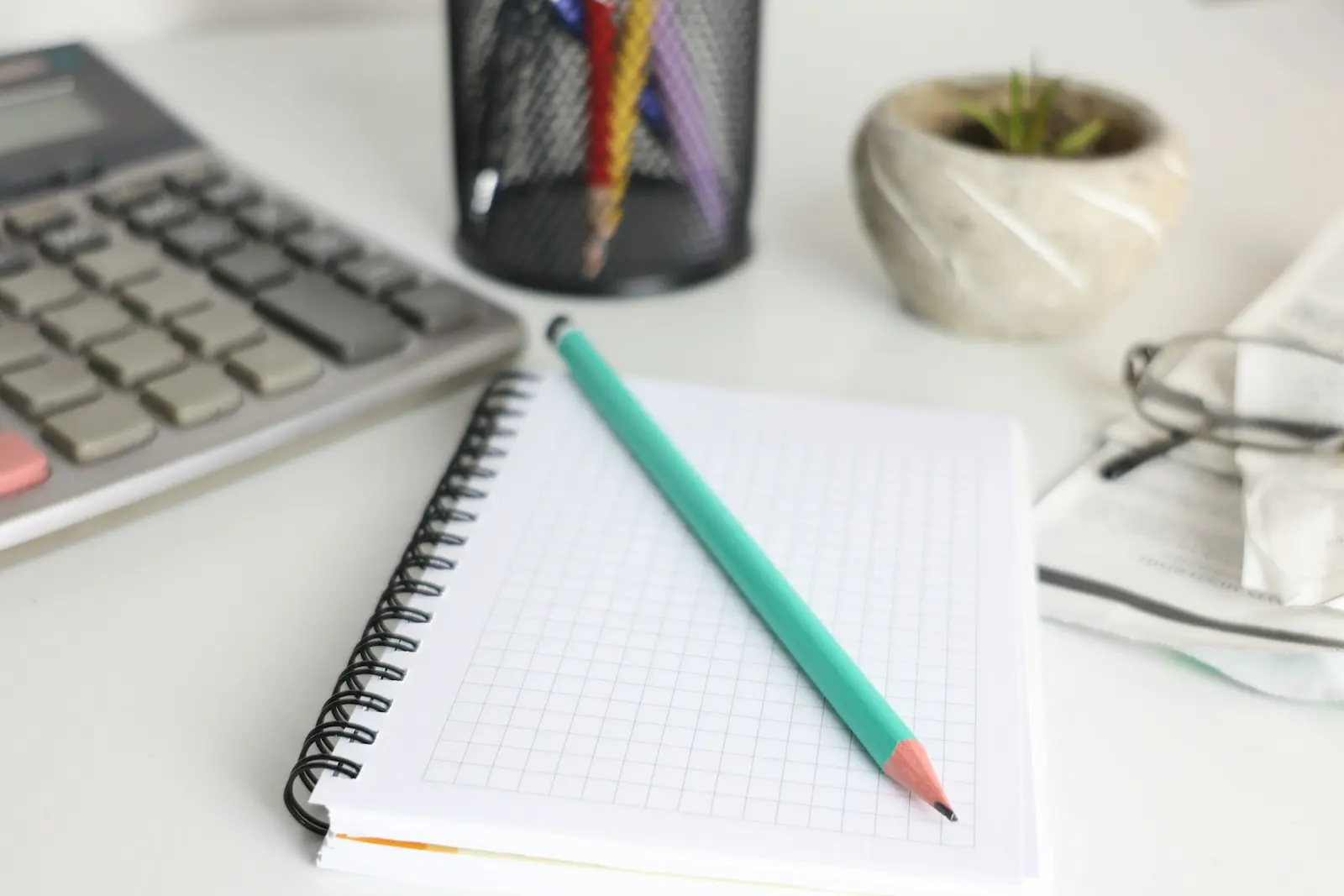 Calculator, notebook and pencil on a work desk