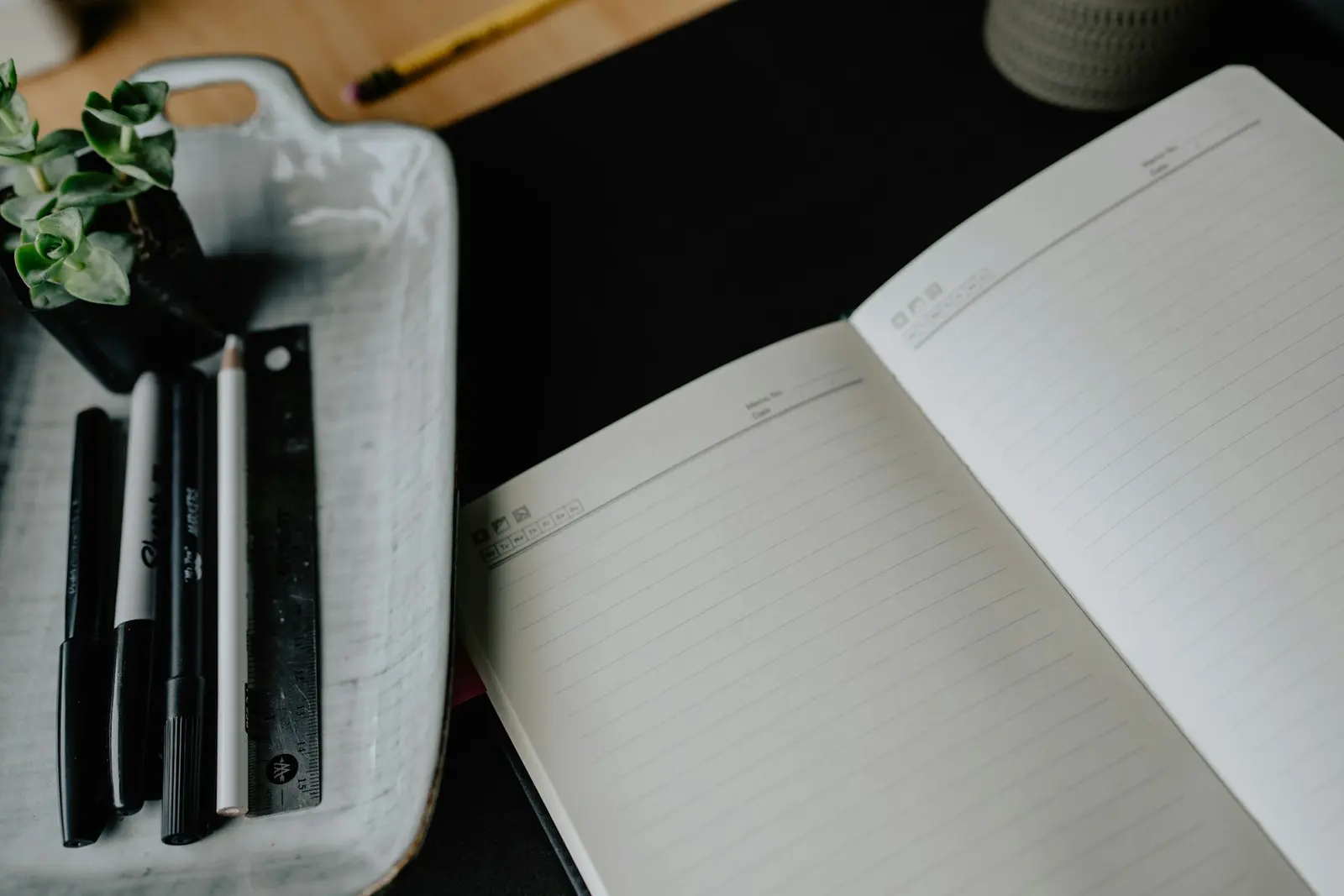 Open notebook and pens on a desk